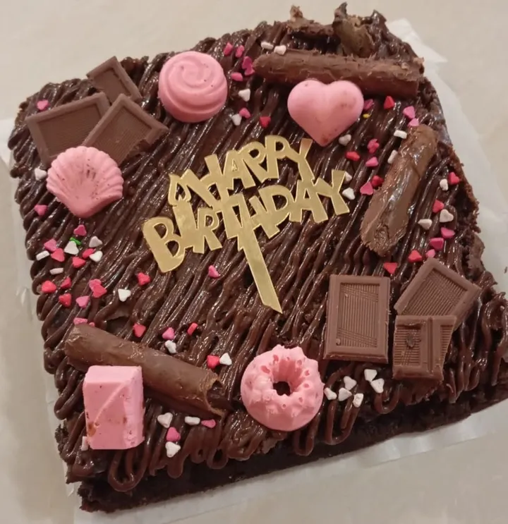 Chocolate birthday cake decorated with chocolates and pink sweets